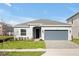 New one-story home with gray siding, gray garage door, and landscaped lawn at 5753 Wallis Ln, St Cloud, FL 34771