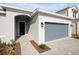 Modern home exterior with gray siding, walkway, and gray garage door at 5753 Wallis Ln, St Cloud, FL 34771