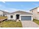 House exterior with gray garage door and landscaping at 5753 Wallis Ln, St Cloud, FL 34771