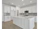 Modern kitchen with white cabinets, large island, and gray backsplash at 5753 Wallis Ln, St Cloud, FL 34771
