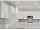 Modern kitchen with white cabinets, gray backsplash, and center island at 5753 Wallis Ln, St Cloud, FL 34771