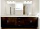 Double vanity bathroom with a large mirror and modern light fixtures at 5783 Greenery Ln, St Cloud, FL 34771