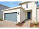 Front view of a one-story home with gray garage door at 5783 Greenery Ln, St Cloud, FL 34771