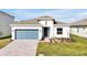 Newly constructed home with a blue garage door and landscaped yard at 5783 Greenery Ln, St Cloud, FL 34771