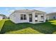 White house exterior with covered patio and nicely landscaped lawn at 5783 Greenery Ln, St Cloud, FL 34771