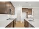 Modern kitchen with dark cabinetry, quartz countertops, and stainless steel appliances at 5783 Greenery Ln, St Cloud, FL 34771