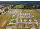 Expansive aerial view of a residential neighborhood with neat, single-story homes, manicured lawns and adjacent green fields at 684 Se 65Th Ter, Ocala, FL 34472