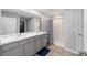 Bathroom featuring a double vanity with marble countertop and tiled shower with glass door at 684 Se 65Th Ter, Ocala, FL 34472