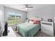 Cozy bedroom with a ceiling fan, bright window, and upholstered headboard at 684 Se 65Th Ter, Ocala, FL 34472