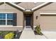 Inviting front entrance with a dark front door, black shutters and charming landscaping at 684 Se 65Th Ter, Ocala, FL 34472