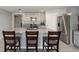 Bright kitchen island with stainless steel appliances and barstool seating with stainless steel refrigerator at 684 Se 65Th Ter, Ocala, FL 34472