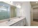 Bathroom with double sink vanity, quartz countertops, large mirror, and walk-in shower with subway tile at 4412 Sw 84Th Street Rd, Ocala, FL 34476