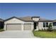 Charming single-story home featuring a well-manicured lawn, neutral stucco siding, and a two-car garage at 4457 Sw 84Th Street Rd, Ocala, FL 34476