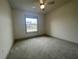 Bright bedroom featuring neutral carpeting and a large window at 7987 Lake James Blvd, Lakeland, FL 33810