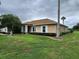 Tan house with a palm tree and well-manicured lawn at 9930 Se 67Th Avenue Rd, Belleview, FL 34420