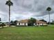 Single story home with a large yard and palm trees at 9930 Se 67Th Avenue Rd, Belleview, FL 34420