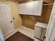 Bright laundry room with white cabinets and tiled floor at 9930 Se 67Th Avenue Rd, Belleview, FL 34420