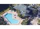 Aerial view of community pool area with ample lounge seating and nearby clubhouse at 3050 Pirates Retreat Ct # 502, Kissimmee, FL 34747