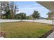 Backyard view showing grassy area, trees, and a white fence at 2724 Oxford St, Orlando, FL 32803