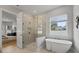 Spa-like bathroom featuring a soaking tub, walk-in shower, and bedroom view at 2724 Oxford St, Orlando, FL 32803