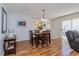 Cozy dining room features a wooden table, seating for four, and natural light from the nearby sliding glass door at 3445 Roanoke St, The Villages, FL 32162