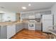 Well-equipped kitchen with white appliances, tiled backsplash, and a breakfast bar for casual dining at 3445 Roanoke St, The Villages, FL 32162