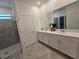 Double vanity bathroom with modern white cabinets and gray tile floor at 1455 Viscaya Cove Blvd, Winter Garden, FL 34787