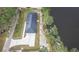 An aerial view of a gray roofed home on a waterfront lot with a large concrete driveway and sidewalk at 225 Diesel Rd, Mulberry, FL 33860