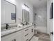 A modern bathroom features double sinks, granite countertops, sleek black fixtures, and white marble-style tiled walls at 225 Diesel Rd, Mulberry, FL 33860