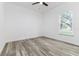 Bright bedroom with gray toned flooring, white walls and trim, ceiling fan and a large window at 225 Diesel Rd, Mulberry, FL 33860