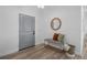 Inviting entryway with stylish wood-look floors, bench seating, and a decorative round mirror at 225 Diesel Rd, Mulberry, FL 33860