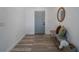 Inviting entryway with stylish wood-look floors, bench seating, and a decorative round mirror at 225 Diesel Rd, Mulberry, FL 33860