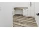 Bright laundry room with gray toned flooring, built in counter top and white shaker cabinets at 225 Diesel Rd, Mulberry, FL 33860