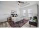 Brightly lit main bedroom with a tray ceiling, accent rugs, and large windows at 225 Diesel Rd, Mulberry, FL 33860