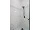 Close up of a newly remodeled bathroom shower with black hardware and marbled tile at 225 Diesel Rd, Mulberry, FL 33860