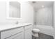 Bathroom with white vanity, tub, and grey tile at 3728 Bergamot St, Lake Alfred, FL 33850