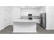Kitchen with white cabinets, granite island and stainless appliances at 3728 Bergamot St, Lake Alfred, FL 33850
