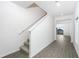Gray vinyl floored hallway with carpeted stairs at 3728 Bergamot St, Lake Alfred, FL 33850