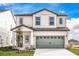 Two-story house with light-colored siding, gray garage door, and landscaping at 3740 Bergamot St, Lake Alfred, FL 33850