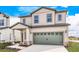 Two-story house with beige siding, gray garage door, and landscaping at 3740 Bergamot St, Lake Alfred, FL 33850