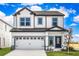 Two-story house with white siding, gray accents, and a two-car garage at 3744 Bergamot St, Lake Alfred, FL 33850