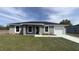 Charming gray home with a well-manicured lawn and a freshly sealed driveway at 13371 Sw 112Th Pl, Dunnellon, FL 34432