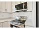 Modern kitchen features stainless steel appliances, white cabinets, and speckled countertops at 2511 Avenue E Sw, Winter Haven, FL 33880