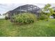 Lush greenery surrounds a screened patio enclosure at 4204 Sevan Way, Kissimmee, FL 34746