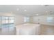 Large kitchen island with white countertop, neutral tiling, and sliding glass doors at 6830 Sw 90Th Loop, Ocala, FL 34476