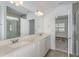 Elegant bathroom with double sinks, quartz countertops, a large mirror, and a glass-enclosed shower, offering a spa-like experience at 9080 Wildlight Trl, Wildwood, FL 34785