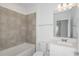 Bathroom features a tiled shower and tub combo, a vanity with sink, toilet, and modern fixtures at 9080 Wildlight Trl, Wildwood, FL 34785