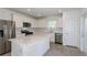 Modern kitchen with stainless steel appliances, white cabinets, a large island, and a tile backsplash, perfect for cooking at 9080 Wildlight Trl, Wildwood, FL 34785