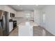 Modern kitchen with stainless steel appliances, white cabinets, a large island, and a tile backsplash, perfect for cooking at 9080 Wildlight Trl, Wildwood, FL 34785