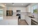 Modern kitchen with stainless steel appliances, white cabinets, a large island, and a tile backsplash, perfect for cooking at 9080 Wildlight Trl, Wildwood, FL 34785